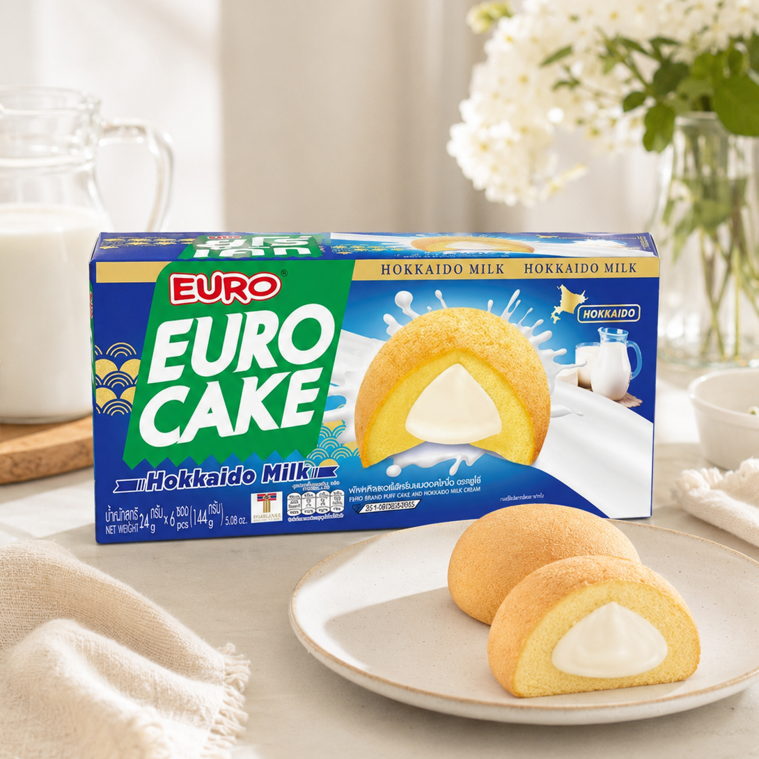 Euro Cake Hokkaido Milk packaging with a slice of cake on a plate, milk jug, and flowers in the background.